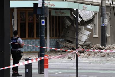 Un agente de policía cierra una intersección donde cayeron escombros sobre la calle después de un sismo en Melbourne, Australia, el miércoles 22 de septiembre de 2021. (James Ross/AAP Image vía AP)