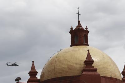 Un helicóptero del ejército mexicano sobrevuela la cúpula de una iglesia el miércoles 22 de junio de 2022, en Cerocahui, México. Dos sacerdotes jesuitas fueron asesinados en el templo. (Foto AP/Christian Chávez)