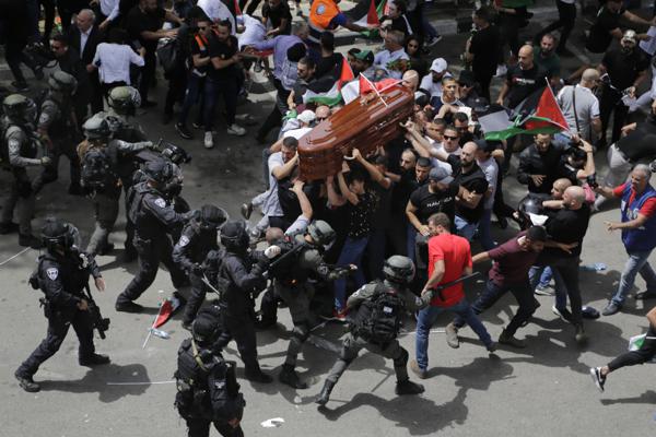 Israeli police clash with mourners as they carry the coffin of slain Al Jazeera journalist Shireen Abu Akleh during her funeral in east Jerusalem, on May 13, 2022. Abu Akleh, a Palestinian-American reporter who covered the Mideast conflict for more than 25 years, was shot dead two days earlier during an Israeli military raid in the West Bank town of Jenin. (AP Photo/Maya Levin)