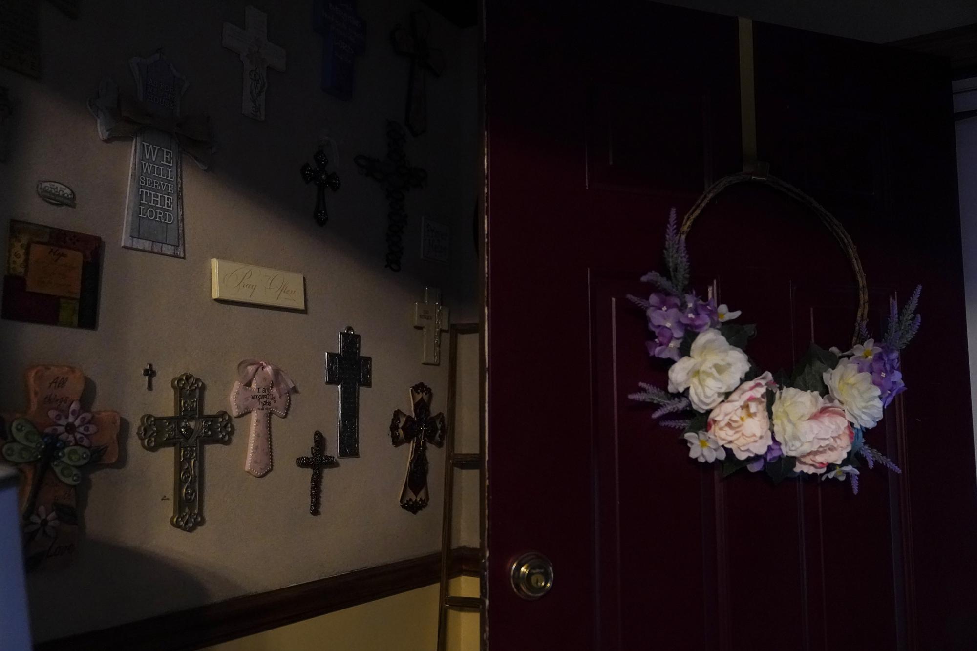 Crosses line a wall in Michelle Branch's home in St. Louis on Monday May 17, 2021. Her 56-year-old brother, Craig Elazer, died of a fentanyl overdose. (AP Photo/Brynn Anderson)