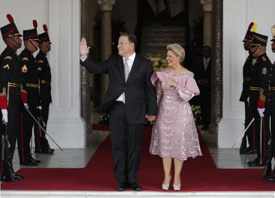 ARCHIVO - En esta fotografía de archivo del 24 de enero de 2019, el entonces presidente de Panamá, Juan Carlos Varela, saluda con la mano mientras él y la primera dama Lorena Castillo se paran en la entrada del palacio presidencial, en la Ciudad de Panamá. Varela y el expresidente Ricardo Martinelli están en la lista de 50 personas que una fiscalía anticorrupción pide llamar a juicio en el caso de sobornos que involucra a la constructora brasileña Odebrecht, dijo la fiscal Tania Sterling, el miércoles 26 de mayo de 2021. (Foto AP / Rebecca Blackwell, Archivo)