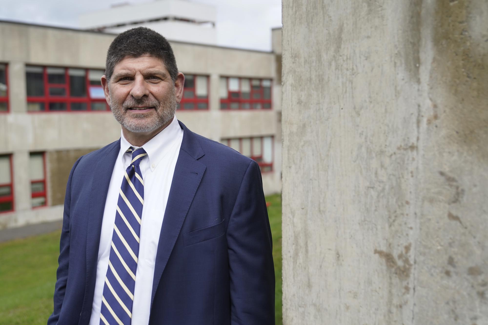 Eric Conti, superintendent of Burlington public schools, stands for a portrait outside administrative offices, in Burlington, Mass., on Tuesday, Oct. 18, 2022. “I can’t imagine a situation where we would close schools again, unless there’s a virus attacking kids,” says Conti. His students alternated between online and in-person learning from the fall of 2020 until the next spring. “It’s going to be a very high bar.” (AP Photo/Steven Senne)
