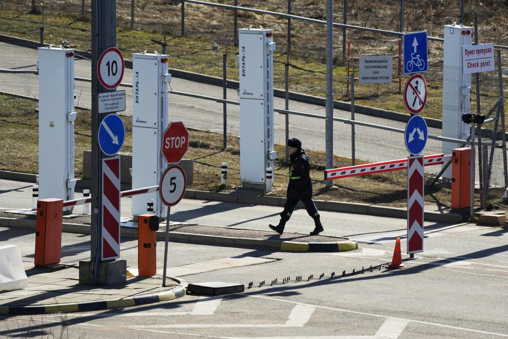 A Russian border guard officer walks at Pelkola border crossing point in Imatra, south-eastern Finland, Friday, April 14, 2023. (AP Photo/Sergei Grits)