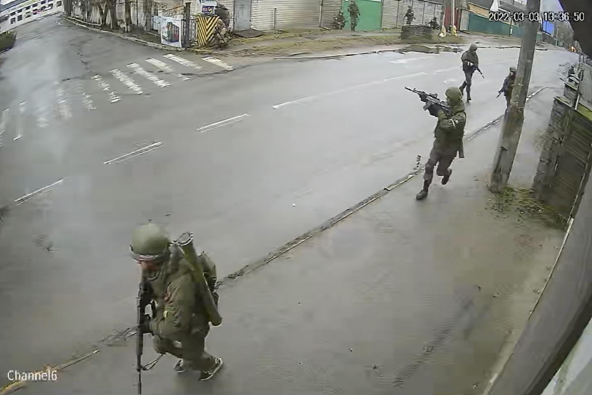In this image from surveillance video, Russian troops take over Yablunska Street in Bucha, Ukraine on March 3, 2022, where they set up a headquarters during their month-long occupation. Police recovered nearly 40 bodies along Yablunksa after Russian forces withdrew at the end of March. (AP Photo)