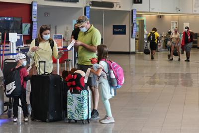 ARCHIVO - En esta foto del 26 de mayo del 2021, una familia se prepara para registrar su equipaje en el Aeropuerto Internacional Hopkins, en Cleveland. Más de 1,8 millones de personas pasaron por los aeropuertos estadounidenses el jueves, 28 de mayo, y se espera que la cifra supere los dos millones durante el fin de semana del feriado por los Caídos en Guerras _ lo que sería el mayor nivel desde inicios de marzo del 2020. (AP Foto/Tony Dejak)