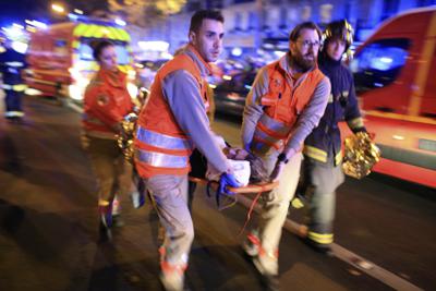 ARCHIVO - En esta foto de archivo del 13 de noviembre de 2015, evacúan a una mujer de la sala de conciertos Bataclan después de un ataque en París. El último sospechoso sobreviviente de los ataques de 2015 en París dijo en un tribunal que se sentía "avergonzado" por no haber podido detonar su cinturón explosivo en la noche sangrienta del 13 de noviembre. (AP Foto/Thibault Camus, File)