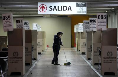 Una mujer limpia el principal centro de votación de la capital en preparación para la segunda vuelta de las elecciones presidenciales en Bogotá, Colombia, el viernes 17 de junio de 2022. (Foto AP/Fernando Vergara)