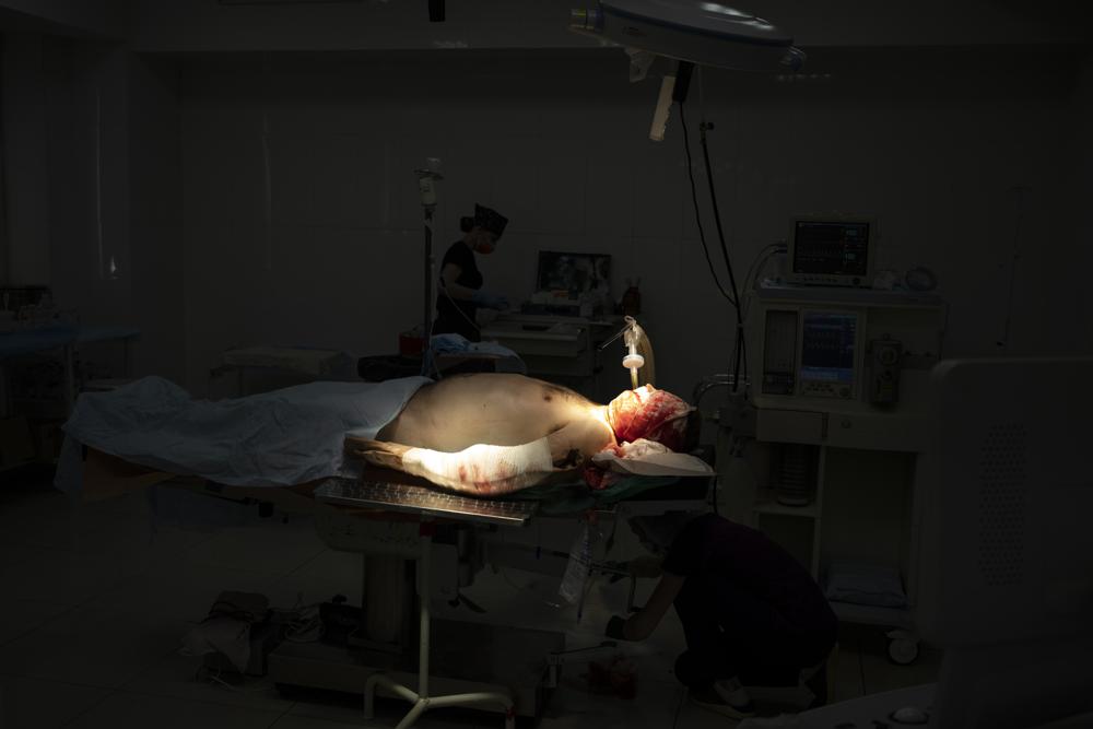 A Ukrainian soldier lays on the operating table before surgery after being injured as the Russian attack continues in Kharkiv, Ukraine, Friday, March 25, 2022. (AP Photo/Felipe Dana)
