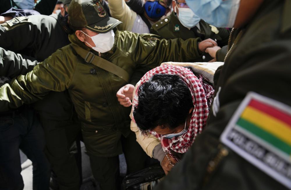 Max Mendoza is escorted in handcuffs by police to San Pedro jail in La Paz, Bolivia, Monday, May 23, 2022. The 52-year-old was detained and sent to jail on Monday after a judge ordered a six-month investigation into allegations his tenure as a state-paid student leader constituted a crime. (AP Photo/Juan Karita)