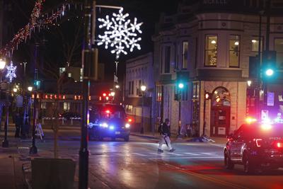 Policías recorren las calles del centro de Waukesha, Wisconsin, el domingo 21 de noviembre de 2021, luego de que una camioneta embistió un desfile navideño. (AP Foto/Jeffrey Phelps)