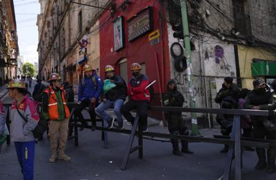 Mineros de oro descansan sobre una barricada policial durante una protesta en las calles de La Paz, Bolivia, el martes 25 de octubre de 2022. (AP Foto/Juan Karita)