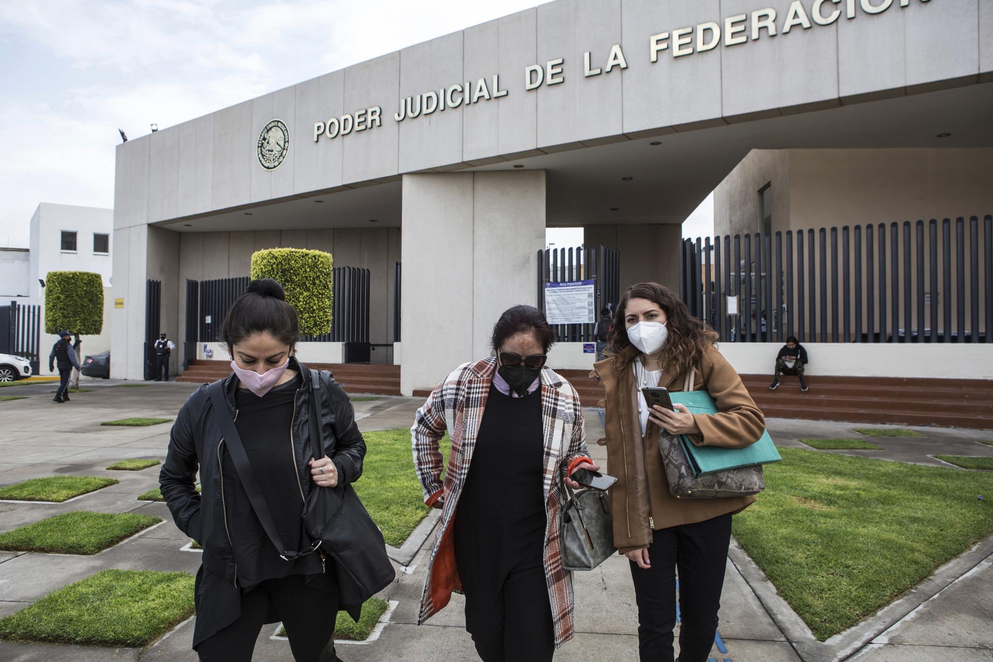Carmen Sánchez, who survived an acid attack by her ex-partner seven years ago when she was 30, walks between her psychologist Jazmín Ramírez, left, and lawyer Jimena Saavedra, as they leave the Federal Judicial Branch building in Ciudad Nezahualcóyotl, State of Mexico, Mexico, Friday, July 22, 2021, after the court cancelled a hearing with Carmen's attacker amid an ongoing investigation into classifying her attack as an attempted femicide. Sanchez started a foundation that bears her name, seeking justice in her case, talking with other survivors, seeking out donors, psychologists and doctors. (AP Photo/Ginnette Riquelme)
