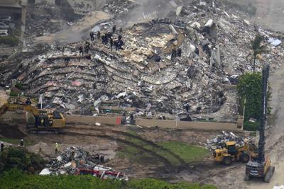 En esta imagen aérea del viernes 25 de junio de 2021, rescatistas laboran en los restos de un edificio en condominio que se derrumbó parcialmente, en Surfside, Florida. (AP Foto/Gerald Herbert)