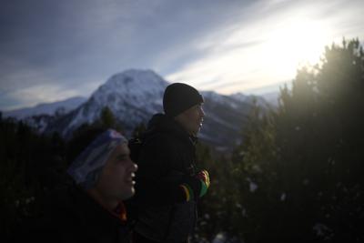 Los migrantes afganos Ali Rezaie, en el centro, y Sayed Hamza caminan por los Alpes francoitalianos hacia un refugio de migrantes en Briançon, Francia, el domingo 12 de diciembre de 2021. Cuando el Talibán tomó el control de Afganistán en agosto, algunos afganos decidieron escapar y emprendieron duros viajes de miles de kilómetros hacia Europa. La odisea de Rezaie por cinco países le ha llevado  hasta los Alpes, donde avanza con la nieve hasta la rodilla para evitar a los guardias de fronteras. (AP Foto/Daniel Cole)