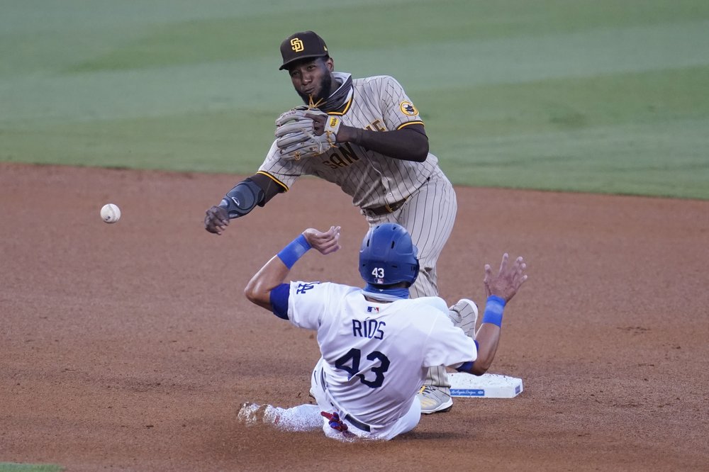 El segunda base de los Padres de San Diego Jurickson Profar (arriba) completa una doble matanza ante Edwin Ríos, de los Dodgers de Los Ángeles, con un rodado de Will Smith en el tercer inning del juego de la MLB que enfrentó a ambos equipos.