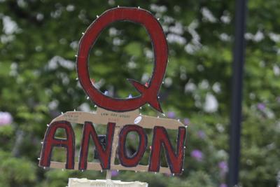Archivo - Una persona fuera de cuadro oirta un letrero en apoyo a la teoría conspirativa QAnon durante una protesta en Olympia, Washington, el 14 de mayo de 2020. (AP Foto/Ted S. Warren, Archivo)
