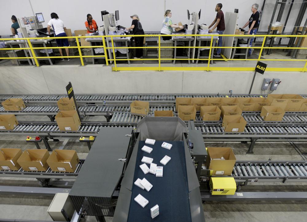 Pharmaceutical orders fall into boxes as workers make sure the orders are complete at Morris and Dickson Co., in Shreveport, Wednesday, July 13, 2016. The U.S. Drug Enforcement Administration has allowed one of the nation’s largest wholesale drug distributors to keep shipping opioid painkillers for nearly four years after a judge recommended in 2018 it lose its license for its “cavalier disregard” of thousands of suspicious orders fueling the opioid crisis. (Henrietta Wildsmith/The Shreveport Times via AP)