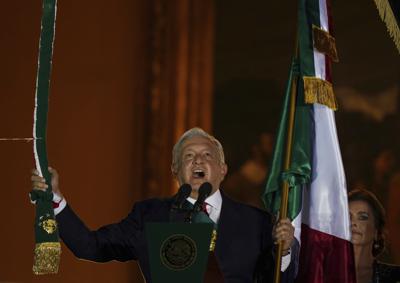 El presidente de México, Andrés Manuel López Obrador, toca una campaaa durante el tradicional "grito" desde el balcón del Palacio Nacional que inicia los festejos por el Día de la Independencia, en la Plaza del Zócalo, en la Ciudad de México, el 15 de septiembre de 2021. (AP Foto/Fernando Llano)