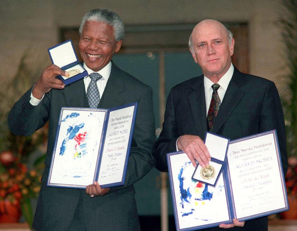 FILE- South African Deputy President F.W. de Klerk, right, and South African President Nelson Mandela pose with their Nobel Peace Prize Gold Medal and Diploma, in Oslo, Dec. 10, 1993. F.W. de Klerk, who oversaw end of South Africa's country’s white minority rule, has died at 85 it was announced Thursday, Nov. 11, 2021. (Jon Eeg/Pool photo via AP, File)