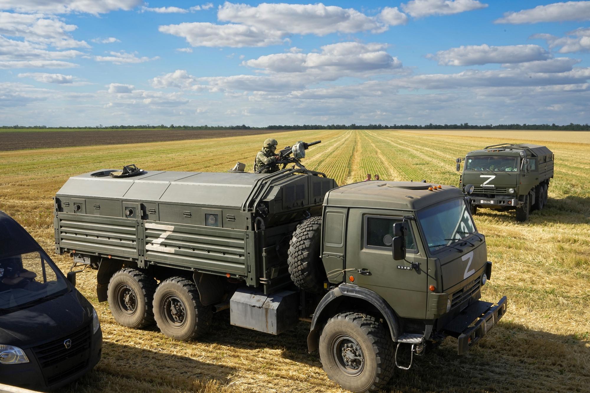 FILE - During a trip organized by the Russian Ministry of Defense, a Russian soldier stands guard atop a military truck as foreign journalists observe farmers at the Voznesenka-Agro farm harvest grain in a field near Melitopol, southern Ukraine, on Thursday, July 14, 2022. (AP Photo, File)