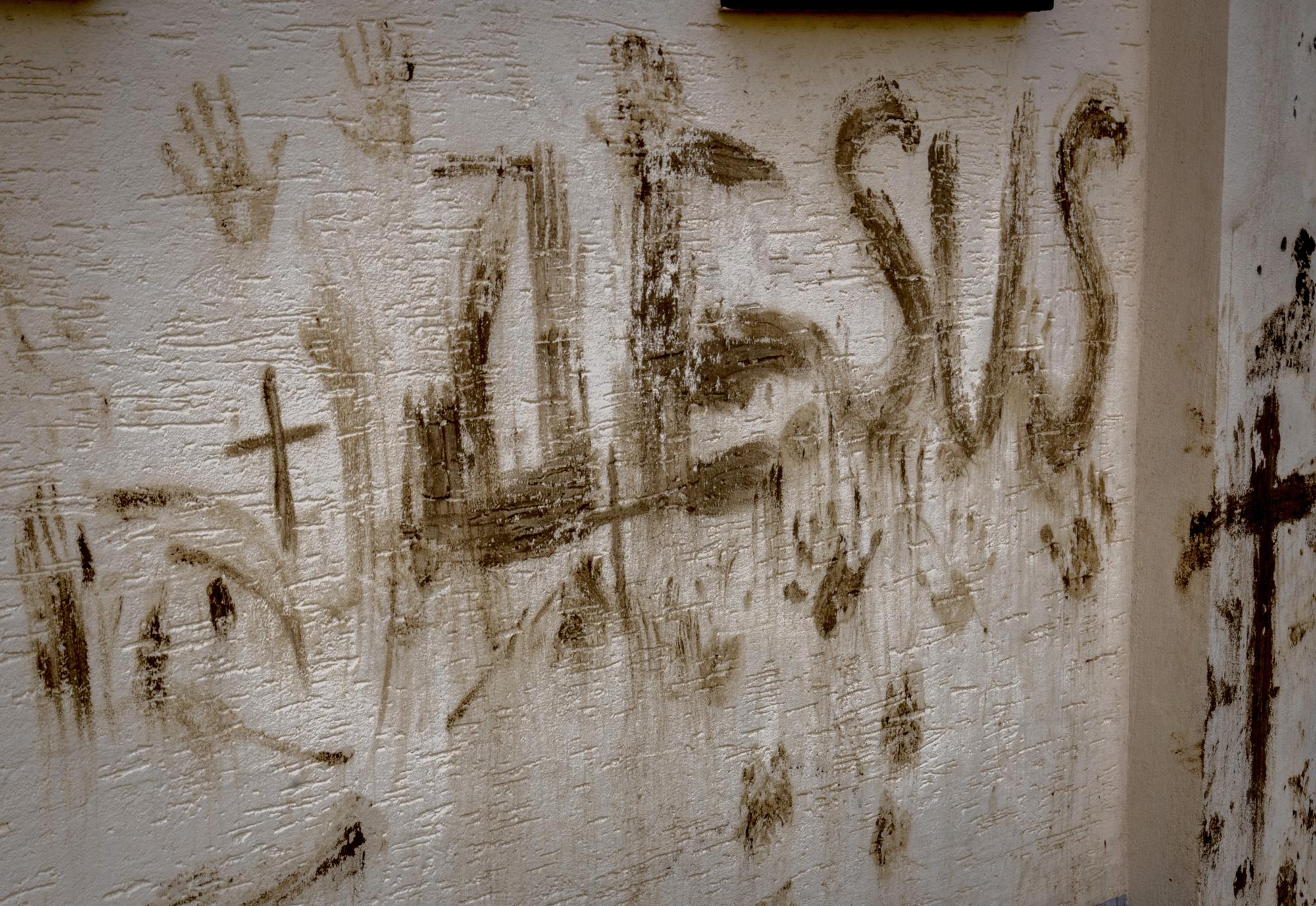 The letters 'Jesus' are written with mud at a damaged house in the village of Ahrweiler in the Ahrtal valley, Germany, Tuesday, July 5, 2022. Flooding caused by heavy rain hit the region on July 14, 2021, causing the death of about 130 people. (AP Photo/Michael Probst)