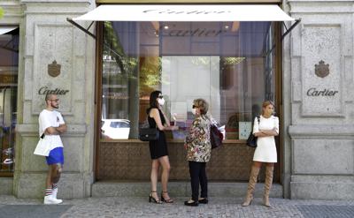 Unas personas esperan formadas afuera de una tienda en Praga, República Checa, el 10 de mayo de 2021. (AP Foto/Petr David Josek)