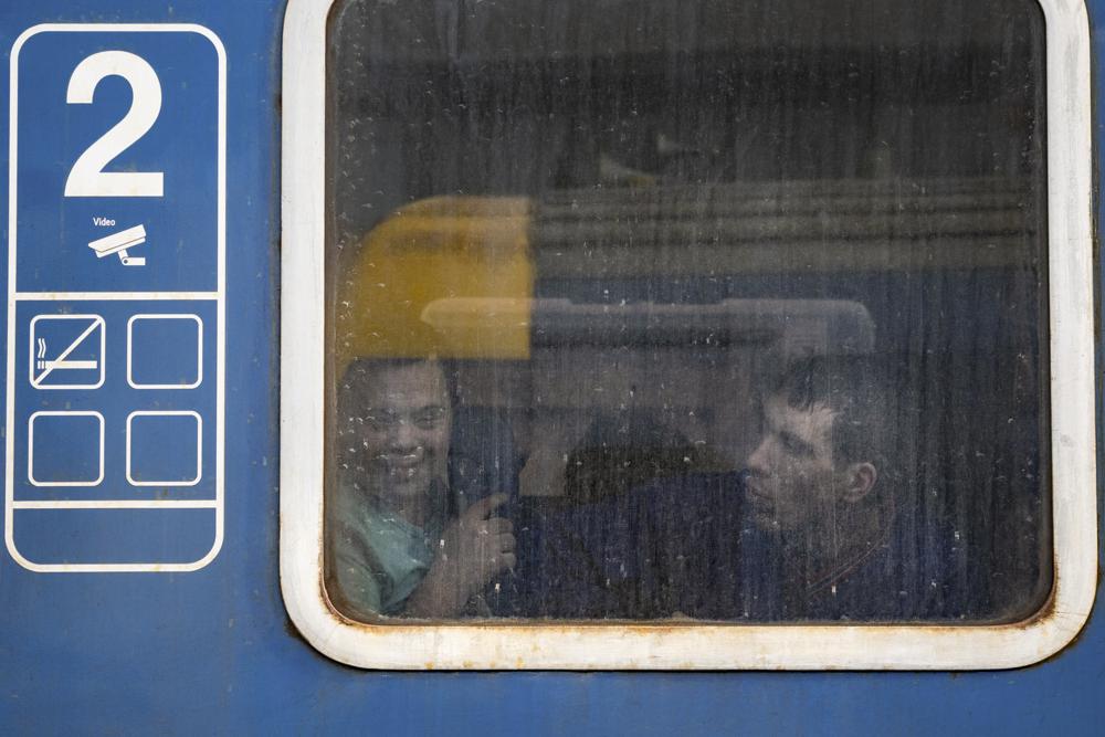 الأشخاص الفارون من الحرب من أوكرانيا المجاورة ينظرون من نافذة قطار ، في زاهوني ، المجر ، الأربعاء ، 2 مارس ، 2022. في محطة القطار في بلدة زاهوني المجرية يوم الأربعاء ، أكثر من 200 أوكراني من ذوي الإعاقة - مقيمون في رعايتين منازل في العاصمة الأوكرانية كييف - نزلت وسط الرياح الباردة لمنصة القطار بعد هروب شاق من أعمال العنف التي تجتاح أوكرانيا.  (AP Photo / Balazs Kaufmann)