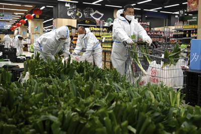 En una imagen proporcionada por la agencia de noticias Xinhua, trabajadores preparan bolsas de artículos comestibles que serán entregadas a los residentes que se encuentran en confinamiento en Xi'an, un poblado del noroeste de China, el miércoles 29 de diciembre de 2021. (Liu Xiao/Xinhua vía AP)