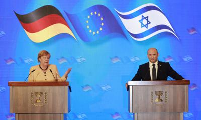 La canciller de Alemania, Angela Merkel, y el primer ministro de Israel, Naftali Bennett, ofrecen una conferencia de prensa conjunta tras una reunión en el Hotel Rey David de Jerusalén, el domingo 10 de octubre de 2021. (Menahem Kahana/Pool via AP)