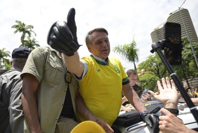 El presidente Jair Bolsonaro, vestido con una camiseta de la selección brasileña de fútbol, hace la señal de la victoria durante un mitin de campaña el sábado 29 de octubre de 2022, en Praca da Liberdade, Belo Horizonte, Brasil, (AP Foto/Yuri Laurindo)