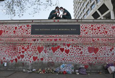 Enfermeras del Hospital St. Thomas están sentadas en el monumento nacional al COVID-19 en Londres, el 27 de abril de 2021. (AP Foto/Frank Augstein, file)