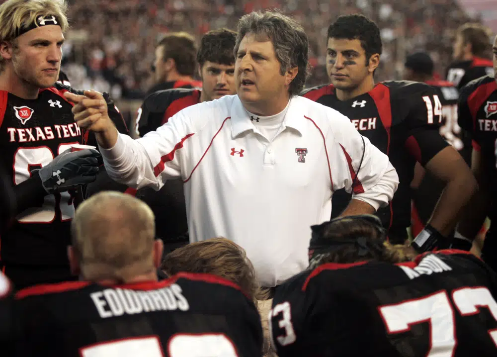 FILE - Texas Tech head coach Mike Leach talks with his team in the second quarter of an NCAA college football game against Texas A&M in Lubbock, Texas, Saturday, Oct. 24, 2009. Mike Leach, the gruff, pioneering and unfiltered college football coach who helped revolutionize the passing game with the Air Raid offense, has died following complications from a heart condition, Mississippi State said Tuesday, Dec. 13, 2022. He was 61. (AP Photo/Mike Fuentes, File)