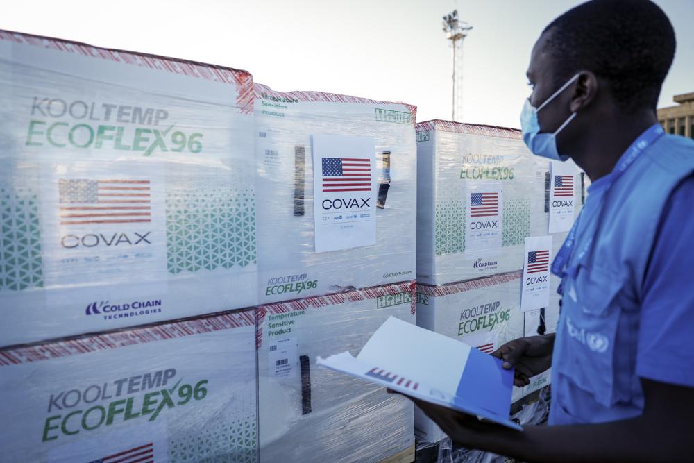 FILE - A UNICEF worker checks boxes of the Moderna coronavirus vaccine after their arrival at the airport in Nairobi, Kenya, Aug. 23, 2021. The emergence of the new omicron variant and the world's desperate and likely futile attempts to keep it at bay are reminders of what scientists have warned for months: The coronavirus will thrive as long as vast parts of the world lack vaccines. COVAX was supposed to avoid such inequality.  (AP Photo/Brian Inganga, File)