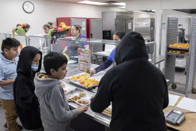 Los estudiantes seleccionan su comida durante la hora del almuerzo en la cafetería de la Academia de Ciencias y Nutrición V. H. Lassen en Phoenix, el martes 31 de enero de 2023. (AP Foto/Alberto Mariani)