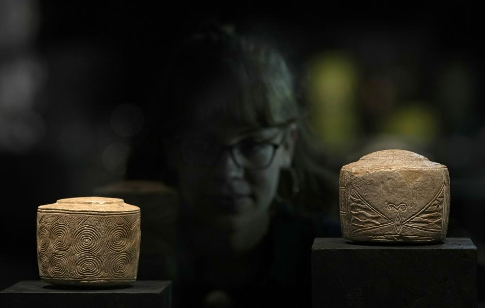 El tambor de tiza Burton Agnes, a la izquierda, hallado en una tumba del año 3000 a.C., y otro tambor antiguo en la exposición "The World of Stonehenge" en el Museo Británico de Londres, el lunes 14 de febrero de 2022. (Foto AP/Alastair Grant)