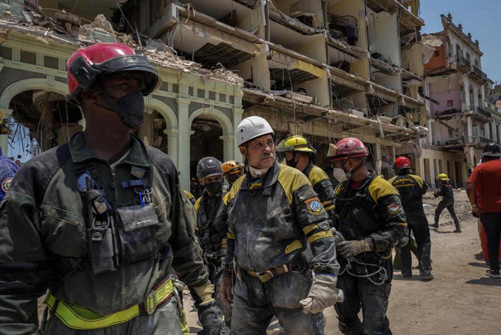 Los equipos de rescate observan después de recuperar un cuerpo de los escombros en el lugar de una explosión mortal que destruyó el Hotel Saratoga de cinco estrellas en La Habana Vieja, Cuba, el lunes 9 de mayo de 2022. (AP Foto/Ramón Espinosa)
