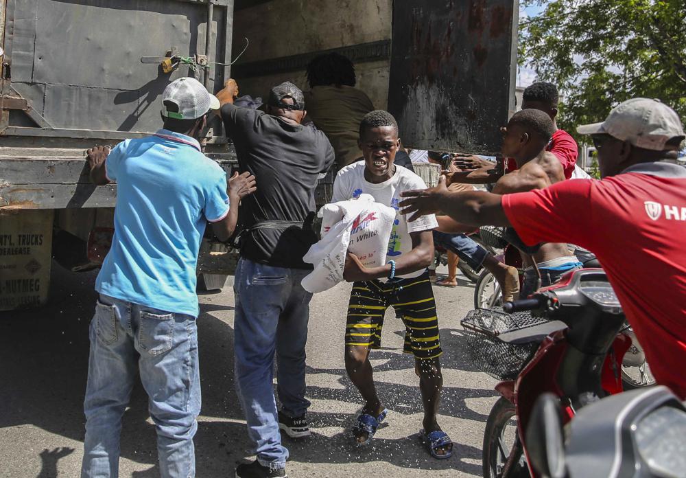 Haitianos acuden por alimento en Les Cayes, Haití, el lunes 16 de agosto de 2021, dos días después de un sismo de magnitud 7,2 que dejó más de mil muertos. (AP Foto/Joseph Odelyn)