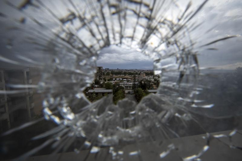 FILE - In this Thursday, May 6, 2021 file photo, the city of Mekele is seen through a bullet hole in a stairway window of the Ayder Referral Hospital, in the Tigray region of northern Ethiopia. Ethiopian military airstrikes have hit the capital of the country's Tigray region Monday, Oct. 18, 2021, according to witnesses. (AP Photo/Ben Curtis, File)