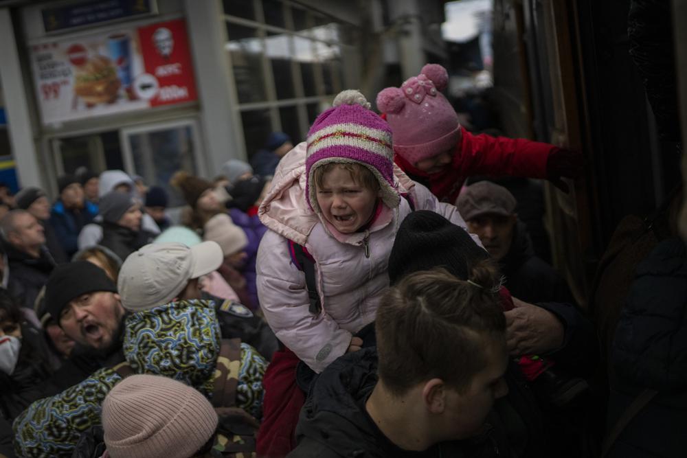 Pessoas segurando seus filhos lutam para pegar um trem para Lviv na estação de Kiev, Ucrânia, segunda-feira, 7 de março de 2022. A Rússia anunciou mais um cessar-fogo e um punhado de corredores humanitários para permitir que civis fujam da Ucrânia. Medidas anteriores desse tipo desmoronaram e as forças armadas de Moscou continuaram a atacar algumas cidades ucranianas com foguetes na segunda-feira. (Foto AP/Emílio Morenatti)