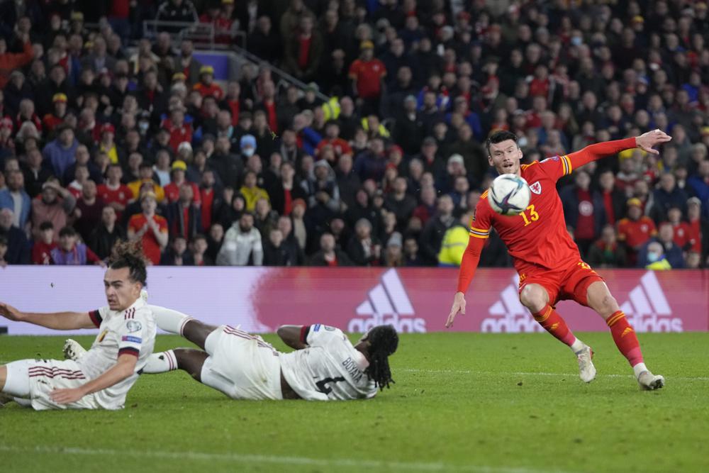 Wales' Kieffer Moore, right, controls the ball past Belgium's Dedryck Boyata, center, and Belgium's Arthur Theate during the World Cup 2022 group E qualifying soccer match between Wales and Belgium at Cardiff City stadium in Cardiff, Wales, Tuesday, Nov. 16, 2021. (AP Photo/Frank Augstein)