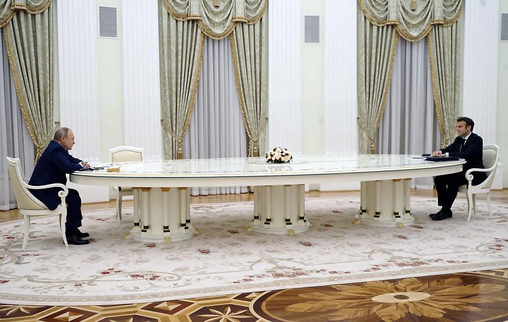 Russian President Vladimir Putin, left, listens to French President Emmanuel Macron during their meeting in the Kremlin in Moscow, Russia, Monday, Feb. 7, 2022. Macron traveled to Moscow in a bid to help defuse tensions amid a Russian troop buildup near Ukraine that fueled fears of an invasion. (Sputnik, Kremlin Pool Photo via AP)