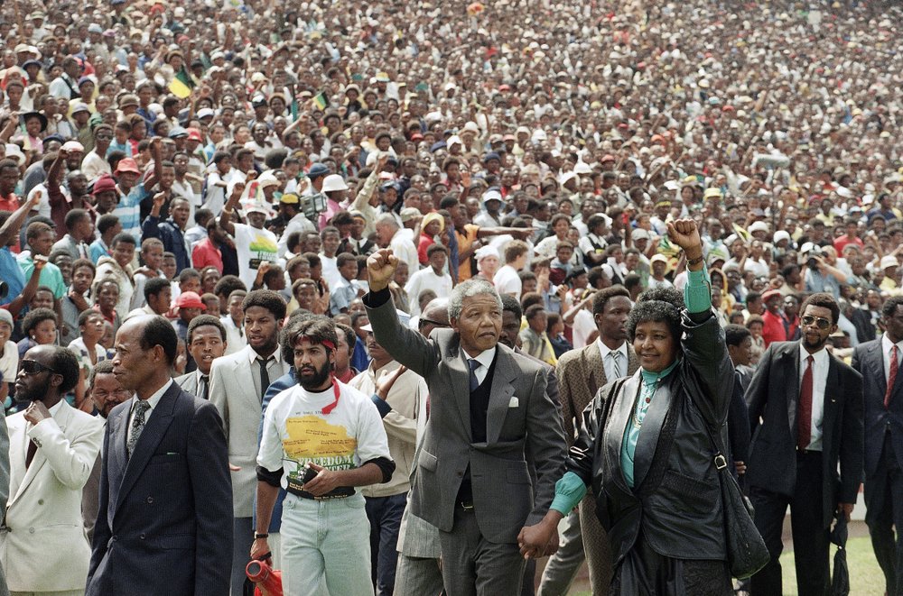 FILE - In this Feb. 13, 1990 file photo, Nelson Mandela and his wife, Winnie Madikizela-Mandela, gesture as they arrive at Soccer City Stadium in Soweto, South Africa two days after after being released after serving 27 years in prison. Mandela's release set off joyous celebrations and violent clashes as supporters welcomed Mandela back from years in jail. (AP Photo/Udo Weitz, File)