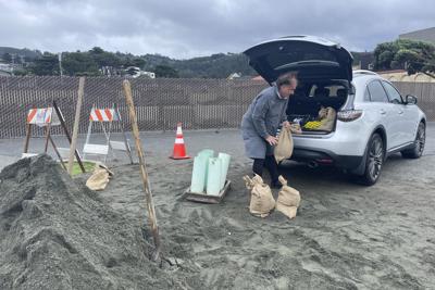 A man loads the back of his car with sandbags, Wednesday, Jan. 4, 2023, in Pacifica, Calif. A major winter storm approached California on Wednesday causing crews to rush to clear storm drains in preparation for flooding and strong winds, as parts of the Midwest dealt with snow, ice or tornadoes, and the South recovered from strong overnight storms. (AP Photo/Haven Daley)