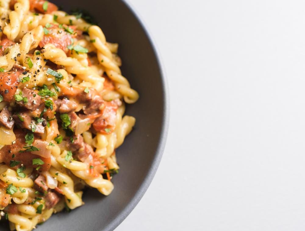 This image released by Milk Street shows a recipe for Gemelli w/Tomatoes, Salami and Fontina. (Milk Street via AP)