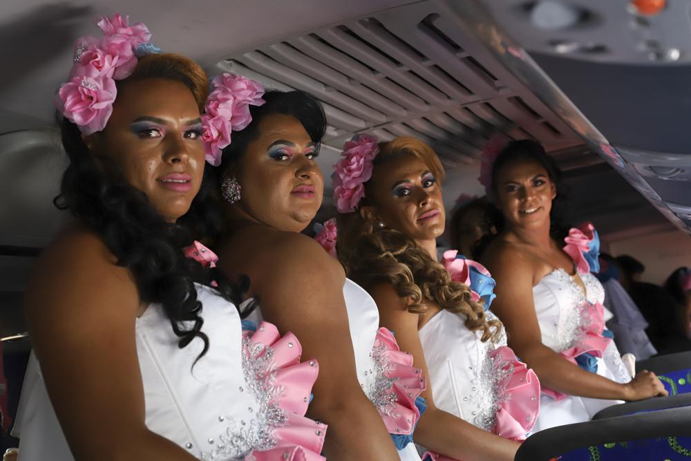 Integrantes de un grupo de desfile del colectivo LGBTQ "Perlas de Oriente" posan para una foto durante la conmemoración del Día Internacional contra la Homofobia, en San Salvador, El Salvador, el lunes 17 de mayo de 2021. Un informe elaborado por esa agrupación indica que las pandillas eran responsables de casi dos tercios de la violencia contra la comunidad LGTBQ, mientras que las autoridades gubernamentales representaron otro 21%. (Foto AP/Salvador Meléndez)