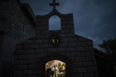 Fray Leopoldo Serrano celebra una misa transmitida a través de Facebook en una capilla en la Misión San Francisco de Asís, Honduras, el sábado 19 de junio de 2021 por la noche. Ubicada en el límite de los departamentos de Santa Bárbara y Copán, su extensa misión se extiende a lo largo del camino que es uno de los principales corredores del narcotráfico de la región. (AP Foto/Rodrigo Abd)