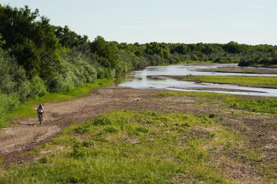 ARCHIVO - Un ciclista recorre en bicicleta un lecho mayoritariamente seco en un tramo del Rio Grande en Albuquerque, Nuevo México, el 27 de julio de 2022. (AP Foto/Brittany Peterson, Archivoe)