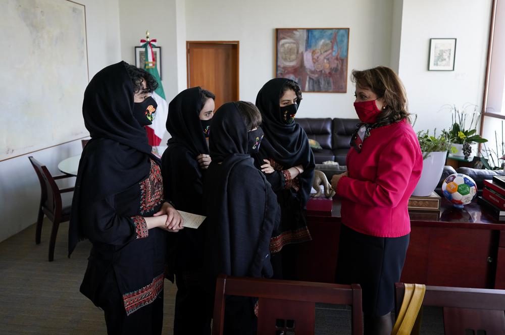Martha Delgado, Undersecretary for Multilateral Affairs and Human Rights at the Ministry of Foreign Relations of Mexico, talks with members of the Afghan all-girls robotics team, after an interview in Mexico City, Wednesday, Aug. 25, 2021. After international efforts and coordination from a diverse group of volunteers to evacuate the team, the girls are begging the international community to help get their families to safety amid evacuations for people fleeing the Taliban takeover as the U.S. pulls out. (AP Photo/Eduardo Verdugo)