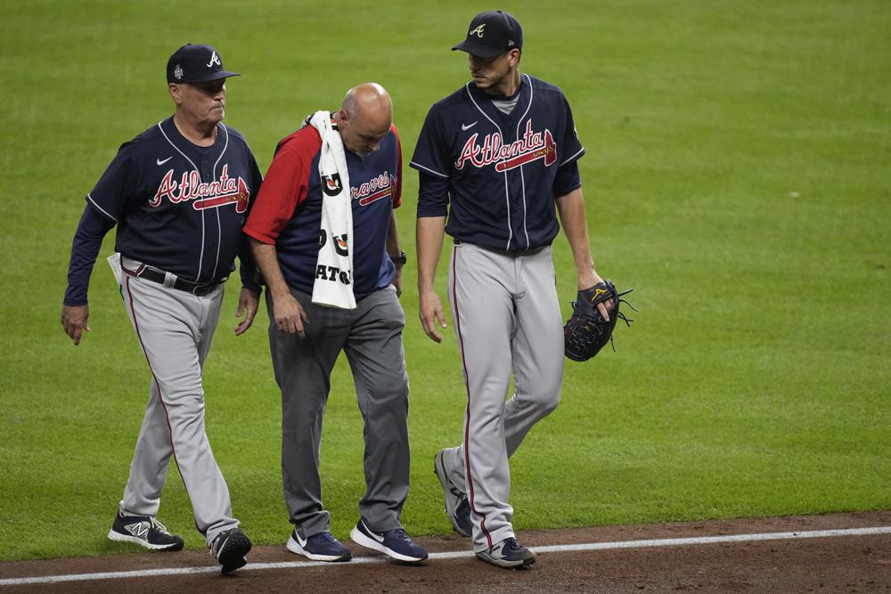 Atlanta Braves starting pitcher Charlie Morton, right, is helped off the field during the third inning of Game 1 in baseball's World Series between the Houston Astros and the Atlanta Braves Tuesday, Oct. 26, 2021, in Houston. (AP Photo/Eric Gay)