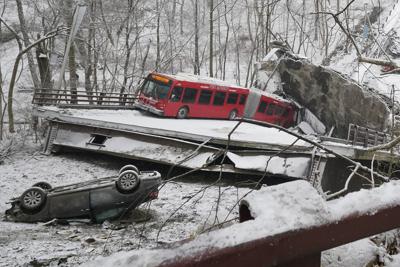 Un autobús y un automóvil que estaban sobre un puente en Pittsburgh cuando colapsó el viernes 28 de enero de 2022 son vistos desde un extremo de la estructura. (AP Foto/Gene J. Puskar)